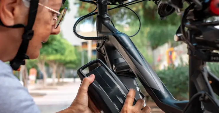 Mann entfernt den E-Bike Akku um ihn zu pflegen