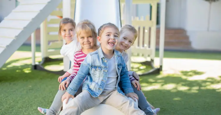 Kinder auf dem Spielplatz in der Nähe einer Grillstelle
